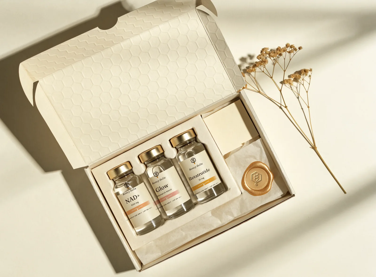 Honey Helix mailer box opened, showing vials, wax-style seal and insert card